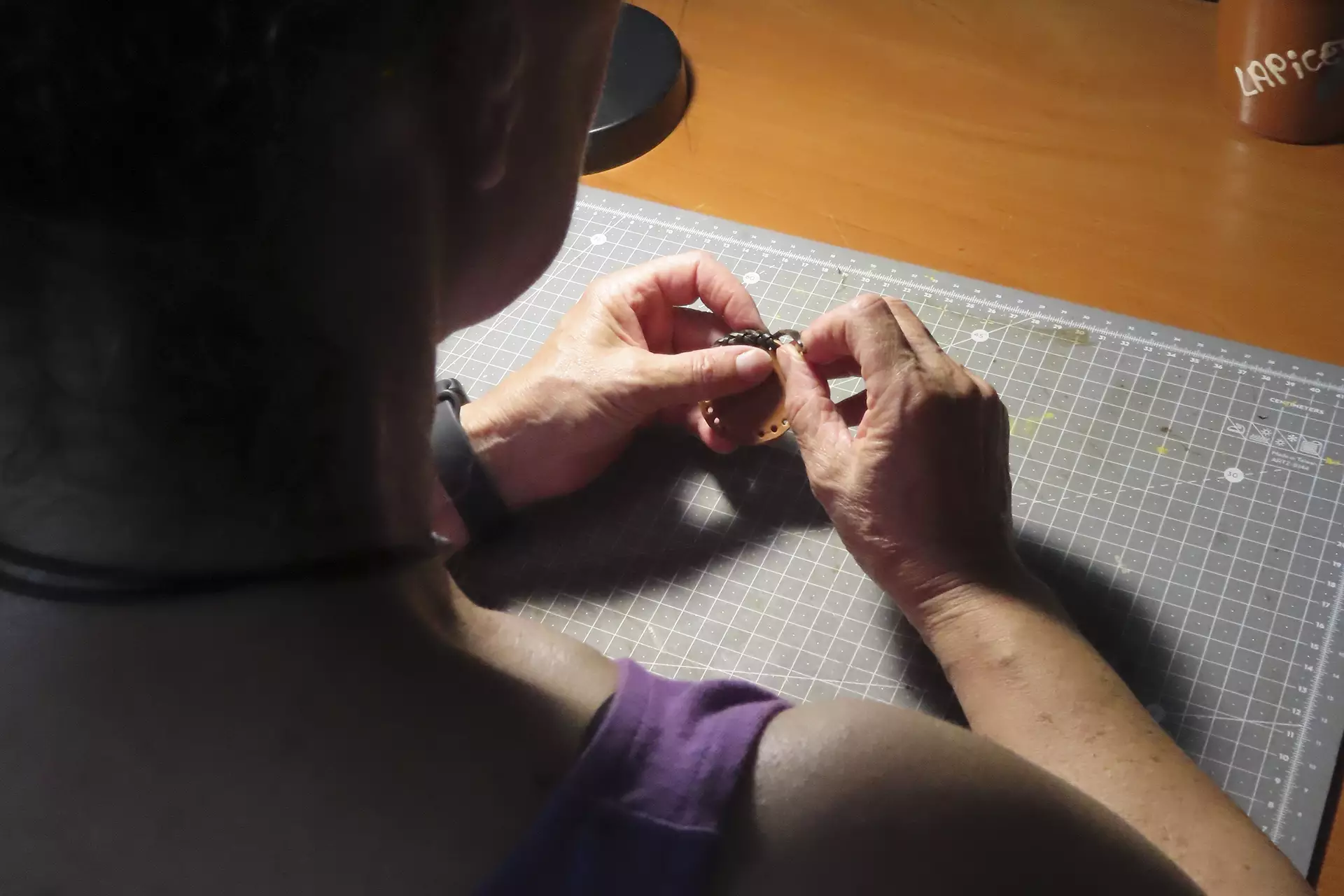 Mujer cosiendo cuero con una aguja